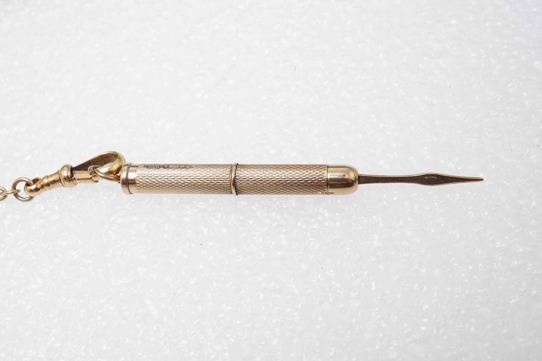 A gold watch chain, toothpick and fob seal